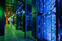 Blick in den Serverraum mit dem Supercomputer HoreKa, im Hintergrund zwei Personen