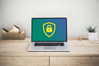 Schreibtisch mit Laptop, auf dem ein Schloss-Symbol zu sehen ist