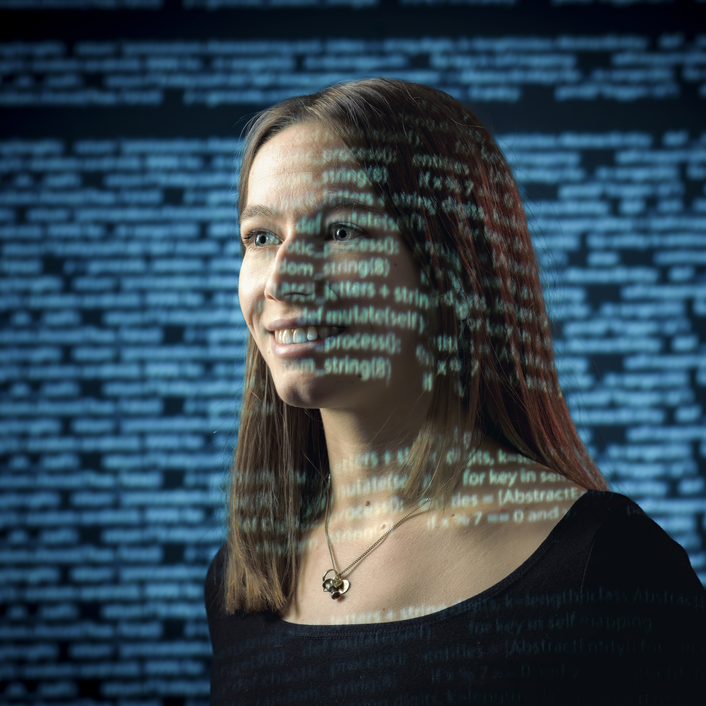 Portr&auml;t einer l&auml;chelnden Frau mit einer dar&uuml;berliegenden Ebene aus Programmcode.