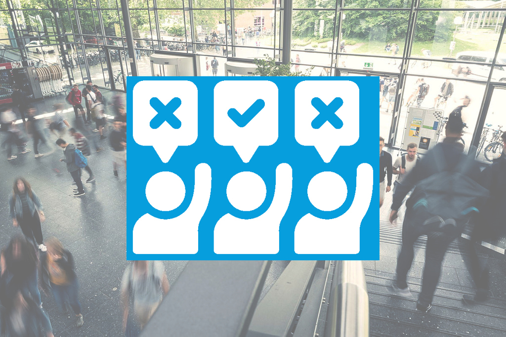 Menschenmenge in einem modernen Gebäude mit Symbolen für Zustimmung und Ablehnung im Vordergrund.