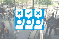 Menschenmenge in einem modernen Gebäude mit Symbolen für Zustimmung und Ablehnung im Vordergrund.