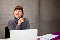 Studentin vor Laptop und Arbeitsmaterialien