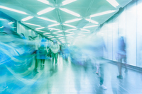 Artistically alienated photo of people walking, who appear blurred by the movement.